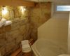 Bad mit romantischer Sandsteinwand und grosser Badewanne